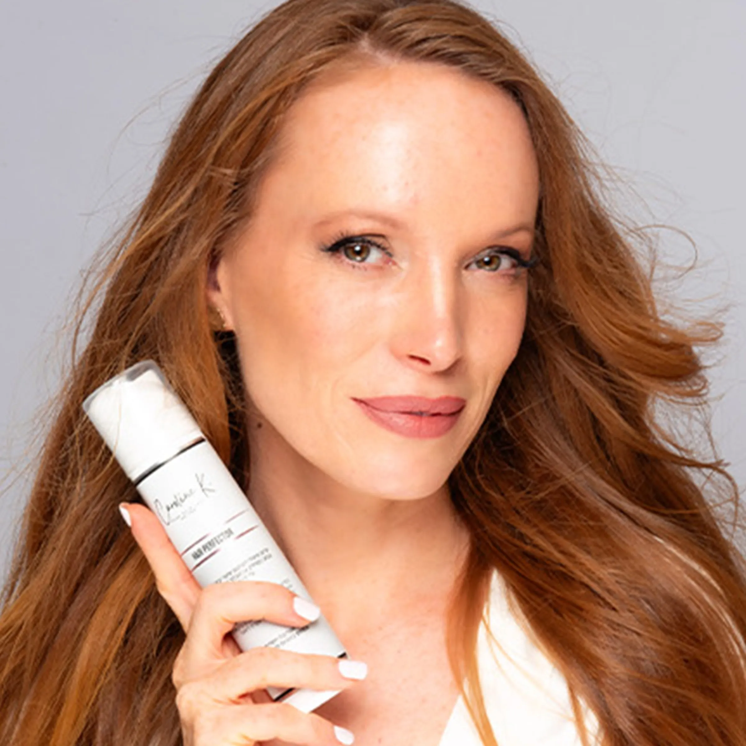 Keren, founder of Caroline K, holding the Hair Perfector serum